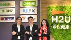 H2U officials pose behind the company's entrance sign