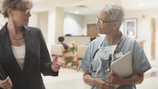 Healthcare provider and another person walking through a care center