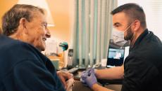 An Atrium Health community paramedic consults with patient in his home.