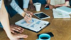 Group of business people examining graphs.