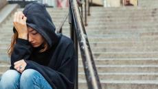 Depressed person sitting on stairs