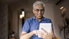 Person at home smiling and looking at a tablet