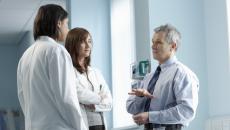 Three healthcare professionals standing in a clinical setting