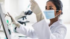 Lab technician examining contents of a test tube