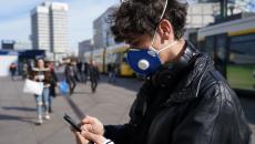 Man in mask uses smartphone