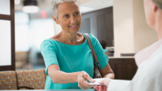 Person handing a piece of paper to a healthcare professional