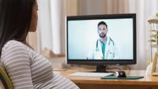 Pregnant person conferring remotely with a healthcare professional