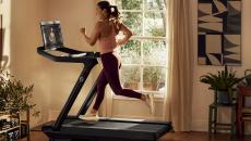 A woman running on a Peloton treadmill