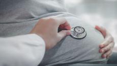 Healthcare provider listening to a person's stomach using a stethoscope