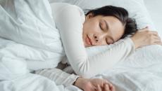 Woman sleeping in an all white bed