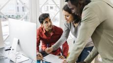 People in an office at a desk talking