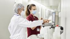 Clinicians reviewing data on a laptop