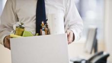 A worker holding a box of his belongings.