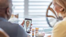 A couple talking to a doctor using a smartphone