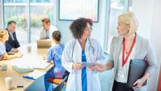 businesswoman and female doctor talking while leaving a conference room