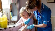 A nurse helping an older woman in her home