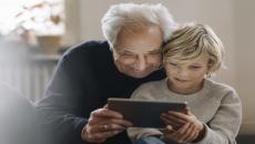 An older man and a child using a tablet