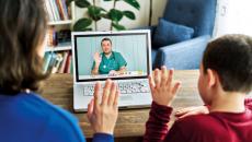 parent and child wave to doctor during a telehealth visit