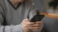 A person sitting in a couch using a smartphone