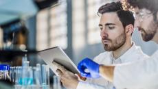 Two scientists looking at a tablet in a lab