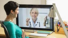 A woman conducts a telemedicine visit.