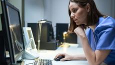 Healthcare provider sitting at a desk while looking at a computer