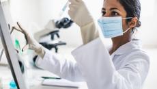 Scientist in a lab looking at a test tube