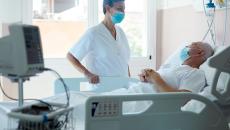 Healthcare provider standing next to a patient in a hospital bed