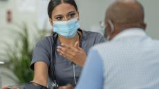 Healthcare provider sitting and talking to a patient