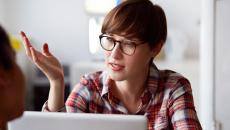 Person wearing glasses and sitting in front of a computer 