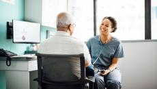 Healthcare provider sitting next to a patient in the clinical setting