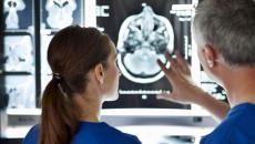 Two surgeons examining a brain scan