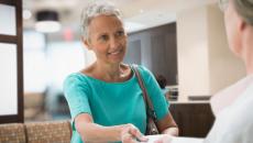 A woman handing her insurance card to a provider