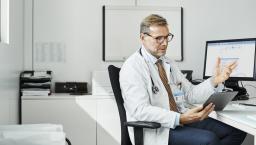 Healthcare practitioners consulting with person on mobile device