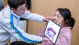 A dentist screening a person's gum using an AI-powered mobile application