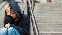 Depressed person sitting on stairs