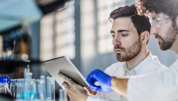 Two researchers in a laboratory using a digital tablet