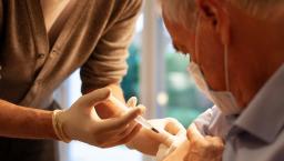 Healthcare practitioners administering injection to patient