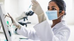 Lab technician examining contents of a test tube