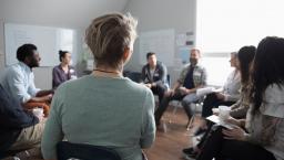 Group of people sitting in a room in a circle