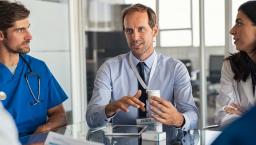 Three healthcare professionals sitting at a table talking