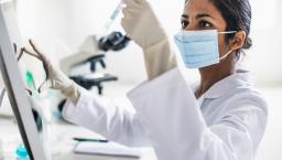 Scientist in a lab looking at a test tube