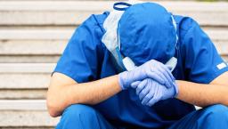 Healthcare provider sitting with their head in their hands