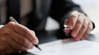 Business person signing a document