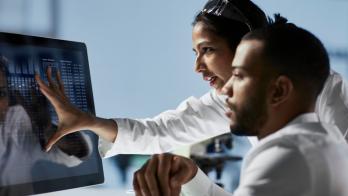 Two healthcare providers looking at a computer screen