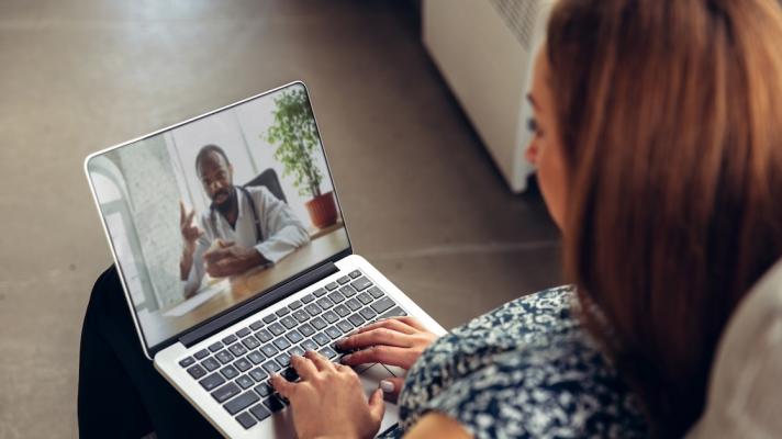 Patient interacting with healthcare professional via laptop