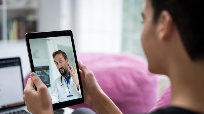 Person talking to a healthcare provider on a tablet