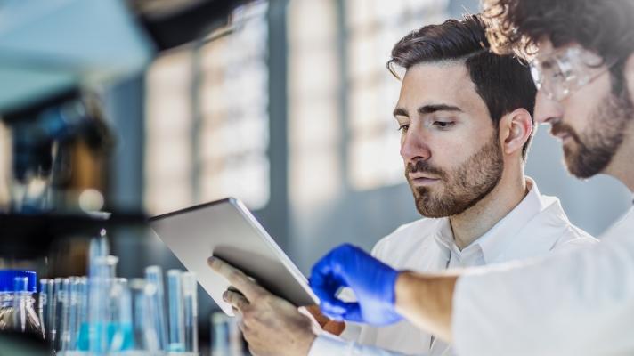 Two researchers in a laboratory using a digital tablet