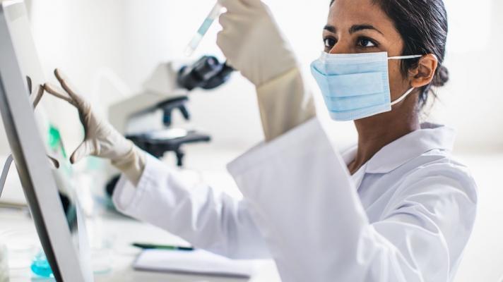 Scientist in a lab looking at a test tube